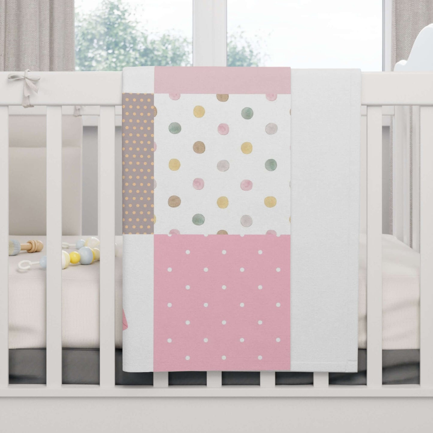 Patchwork Design Baby Girl Blanket with Personalization draped over a crib, featuring colorful dots and patterns.
