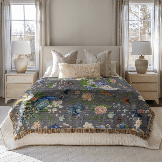 Dark Gray Peacock Floral Woven Blanket with Fringes draped over a bed in a bright bedroom