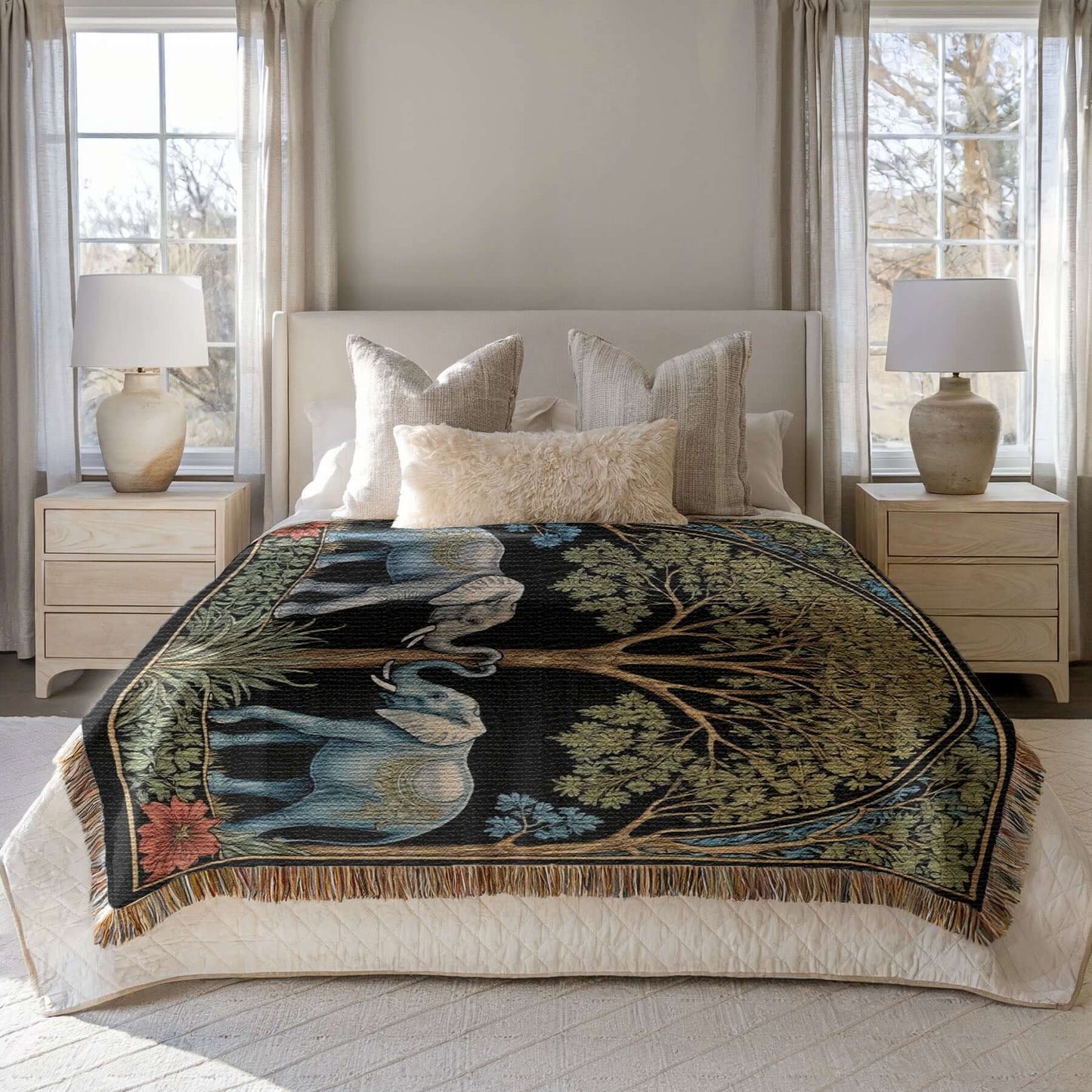 Two elephants on a woven fringed blanket spread out on a bed.
