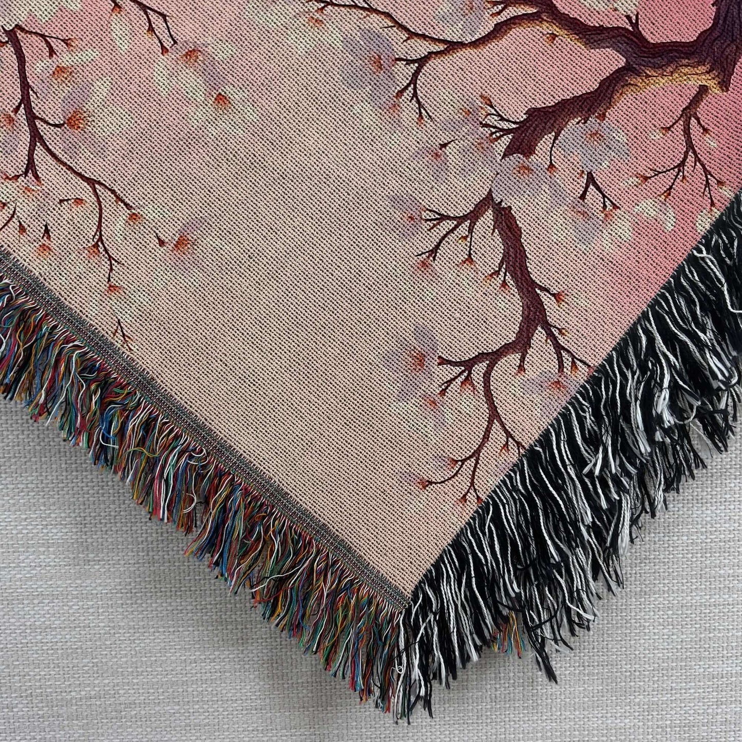 Closeup corner view of the Pink Almond Blossom Woven Blanket.