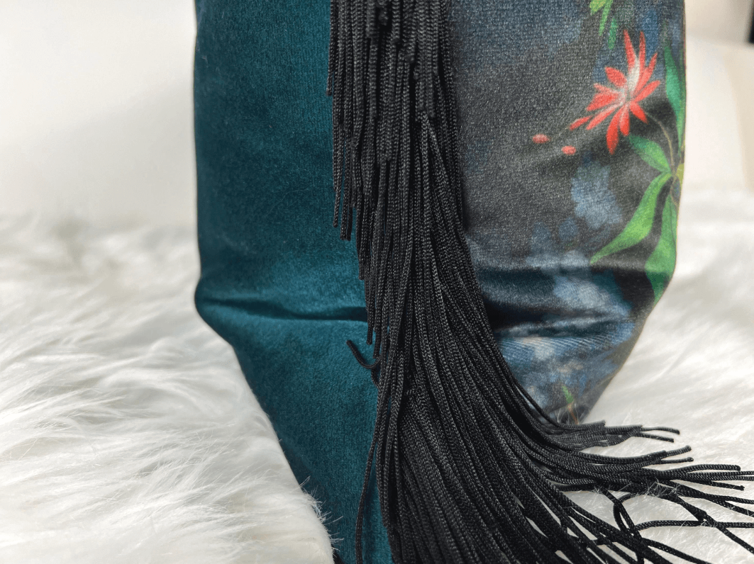 Closeup side view of the Floral Velvet Lumbar Pillow Cover with Chainette Fringe paired with a blue pillow against a white background