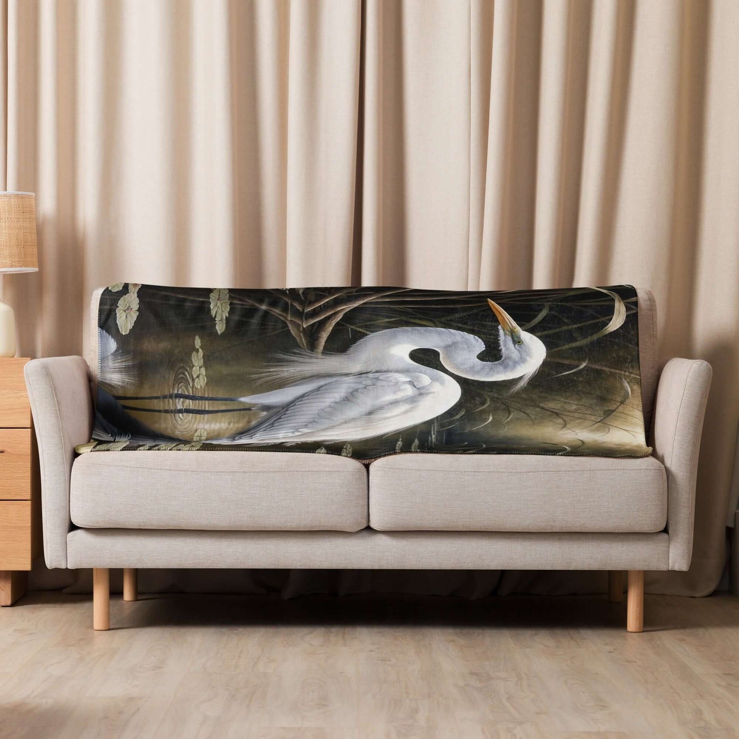 Great Egret Printed Sherpa Blanket on white sofa in front of a beige curtain
