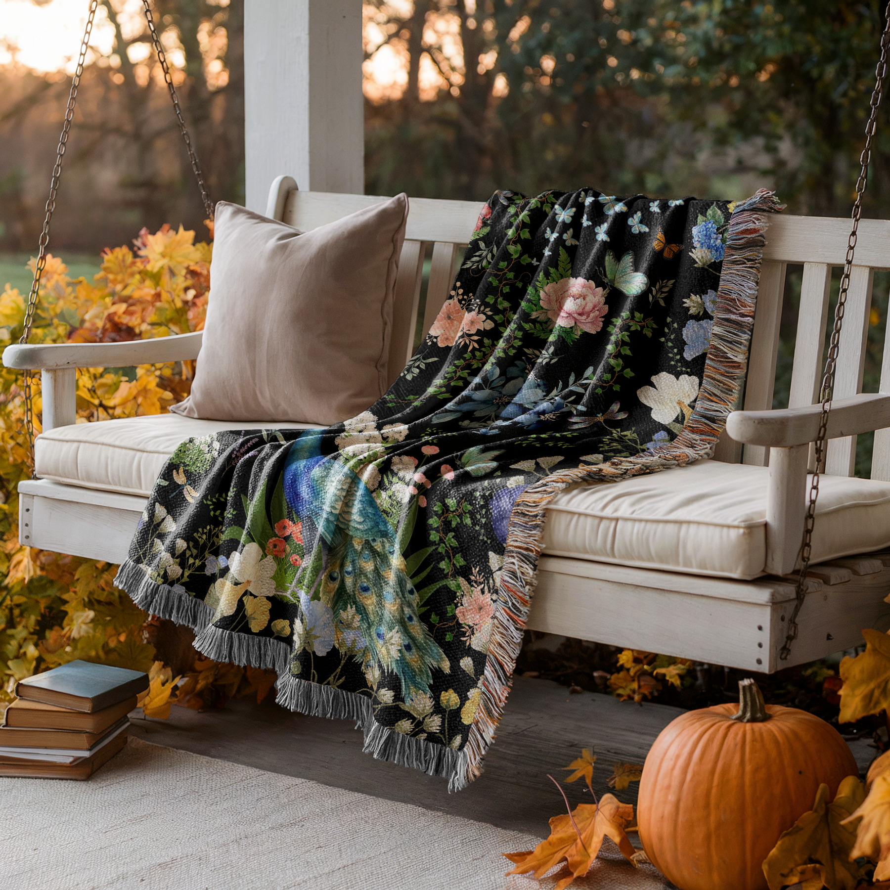 Black Peacock Floral Woven Blanket with Fringes displayed on a porch swing surrounded by autumn decor.
