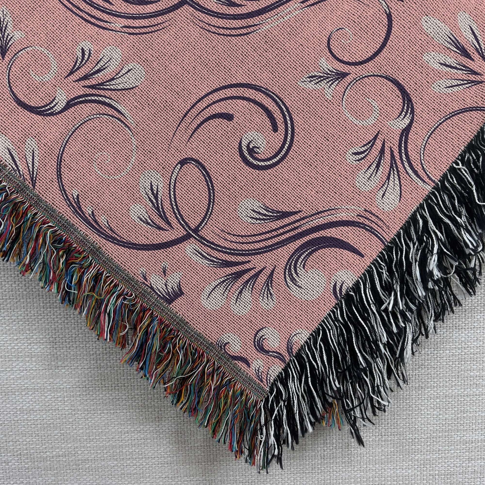 Pink Floral Damask Woven Blanket with intricate jacquard weave detail and colorful fringe.