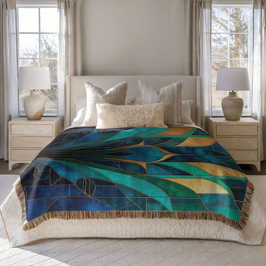Blue and Teal Abstract Stained Glass Blanket elegantly draped on a bed in a cozy bedroom, showcasing its vivid colors and fringe trim.