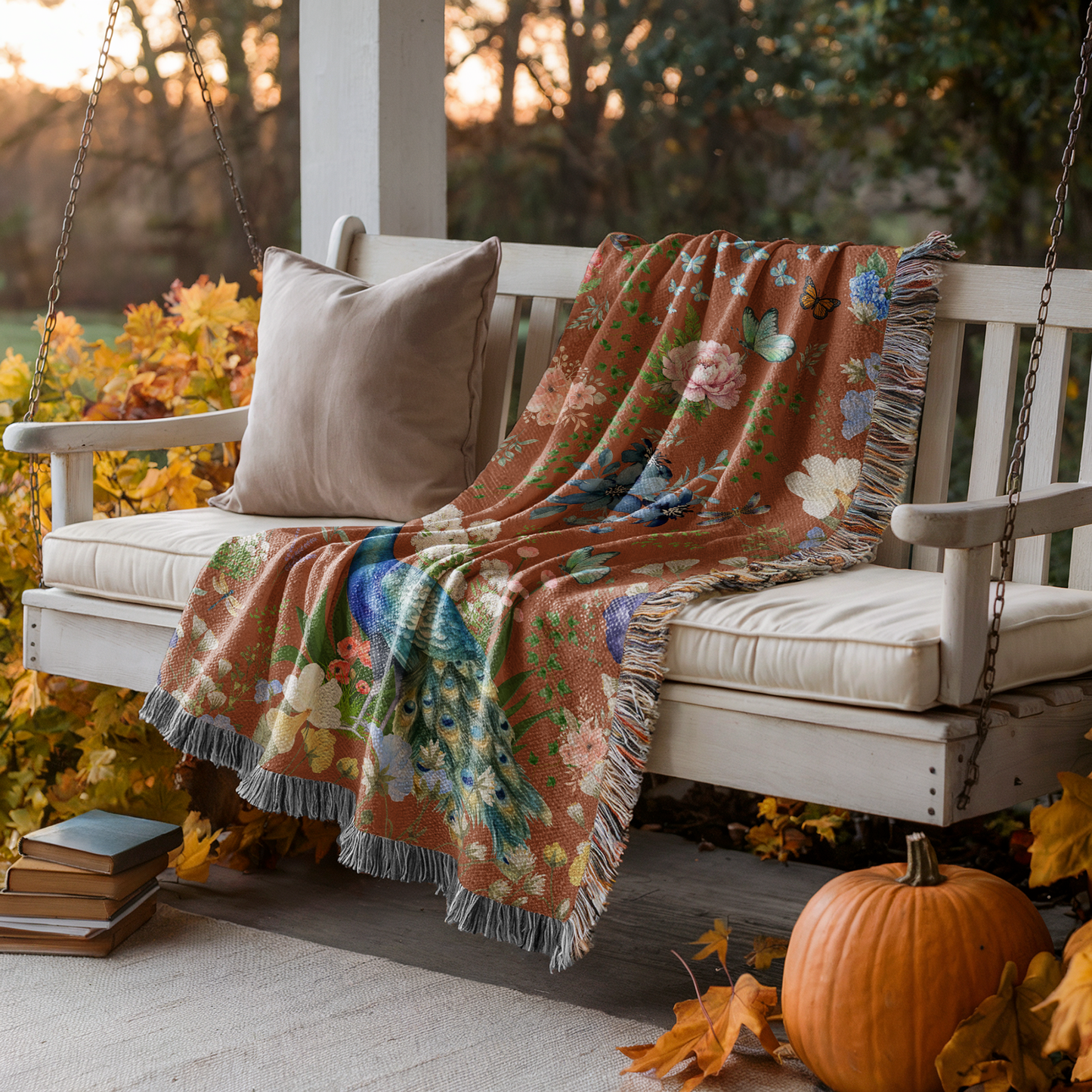 Cinnamon Brown Peacock Floral Woven Blanket draped on a wooden porch swing on a porch with a pumpkin