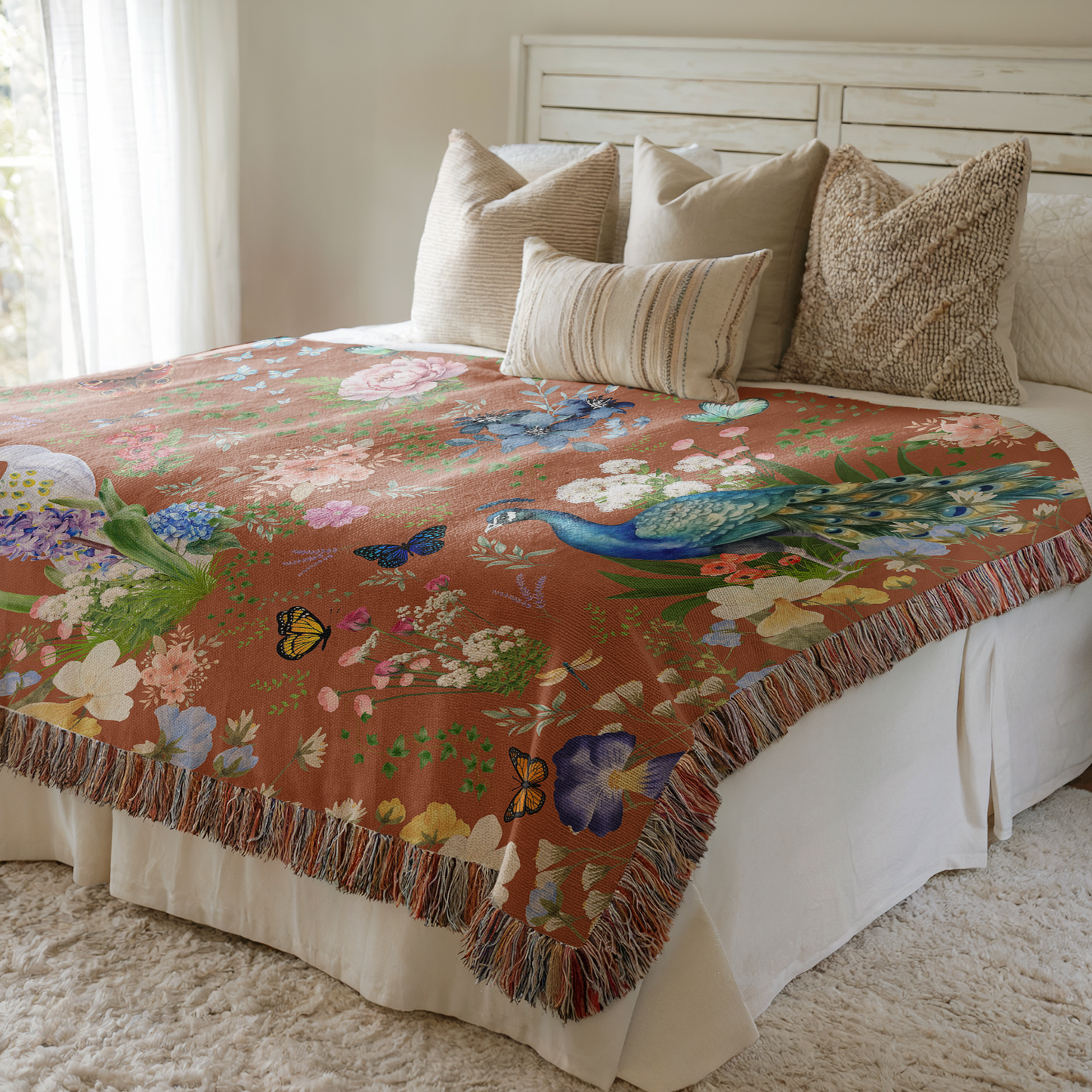 Cinnamon Brown Peacock Floral Woven Blanket draped on a bed with beige pillows