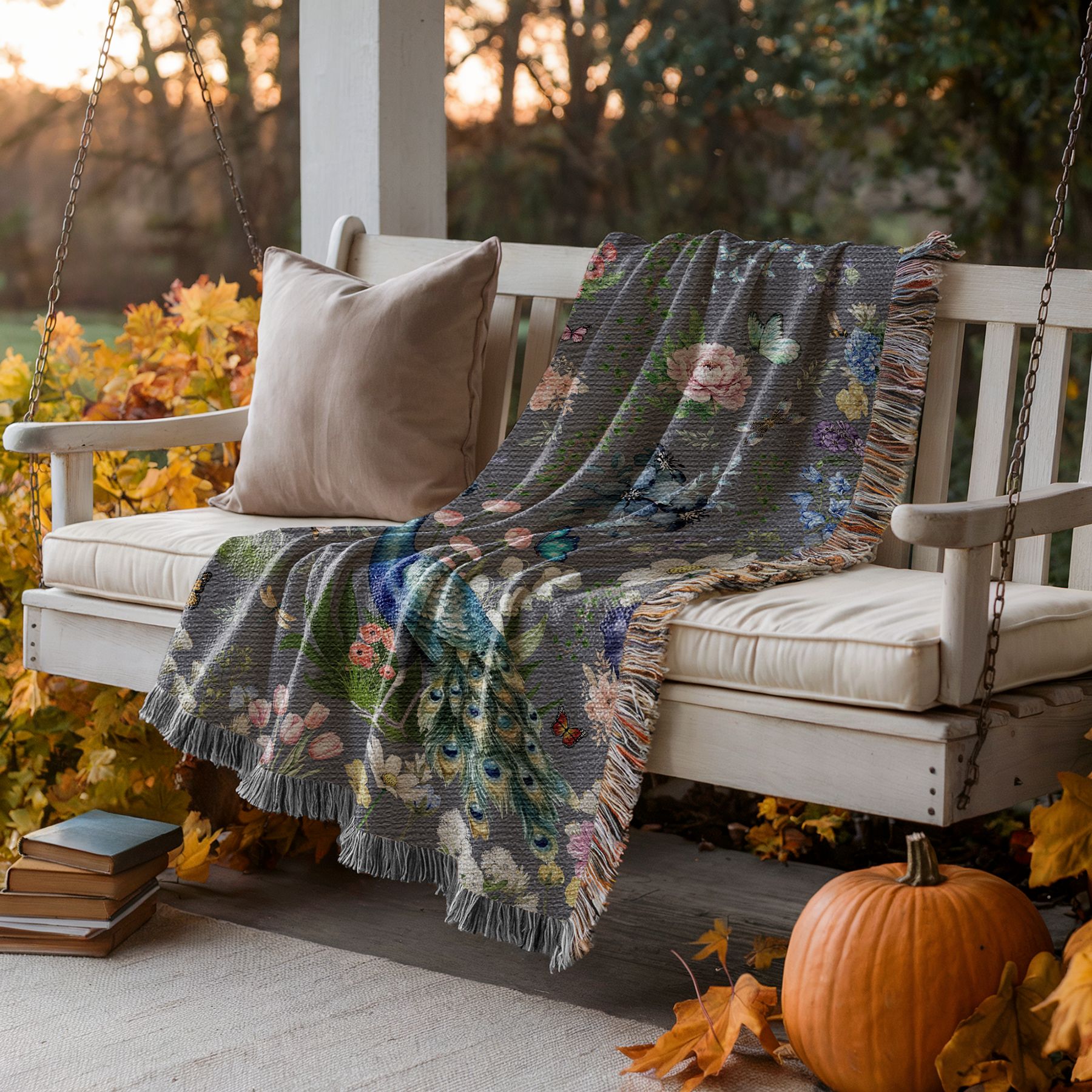 Dark Gray Peacock Floral Woven Blanket with Fringes on a porch with pumpkins and books.