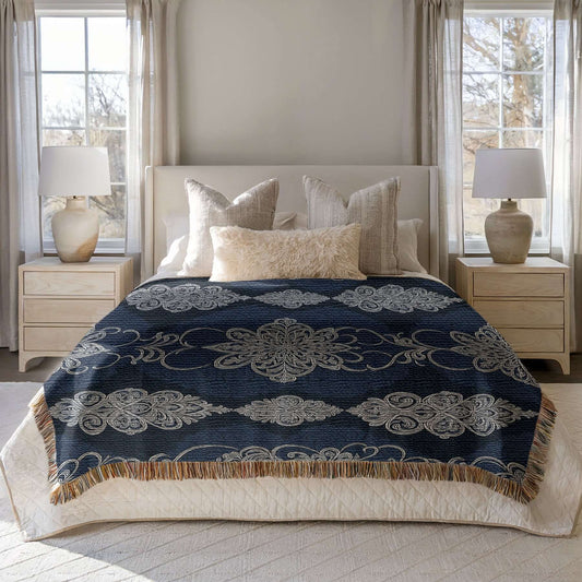 Navy White Damask Woven Blanket displayed on a bed with decorative pillows and lamps, showcasing its elegant design.