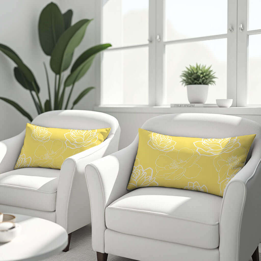 Two yellow and white pillows on two white armchairs.