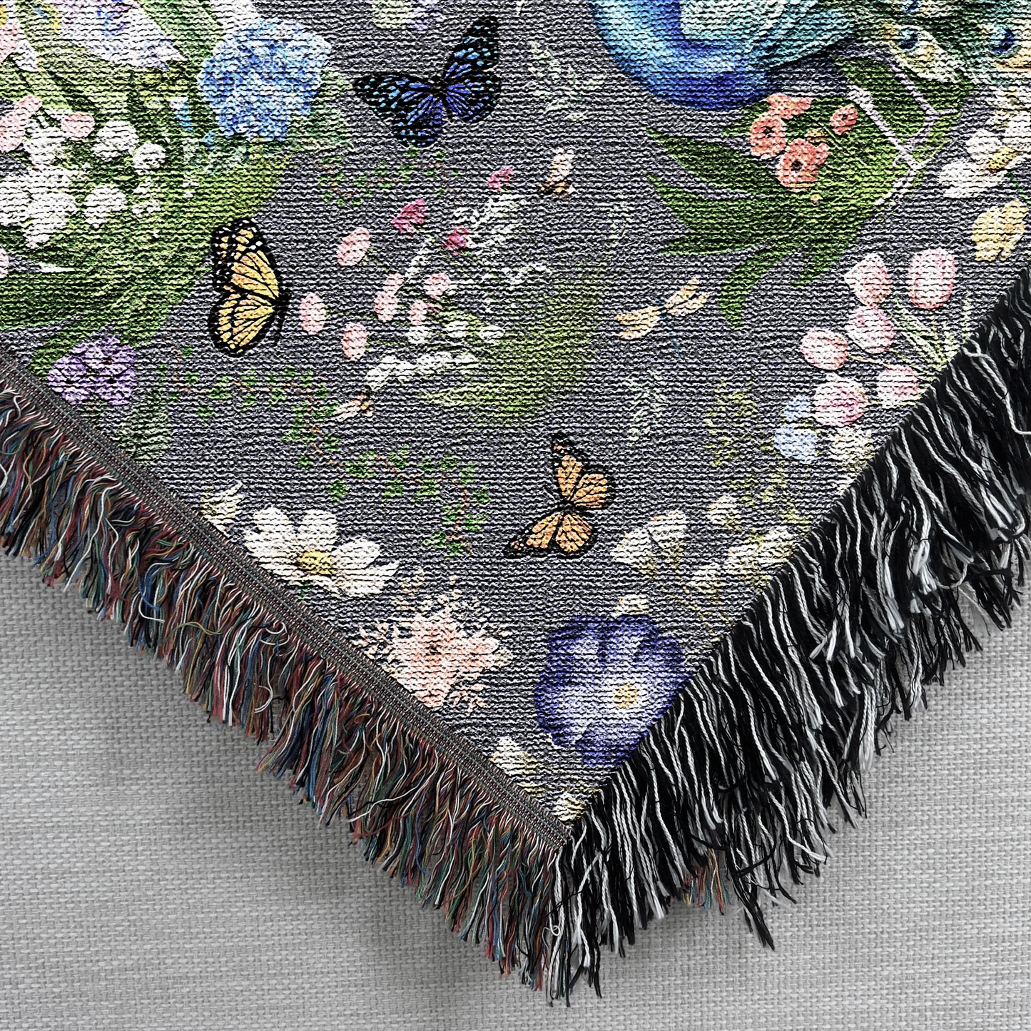 Closeup corner view of the Dark Gray Peacock Floral Woven Blanket with Fringes 