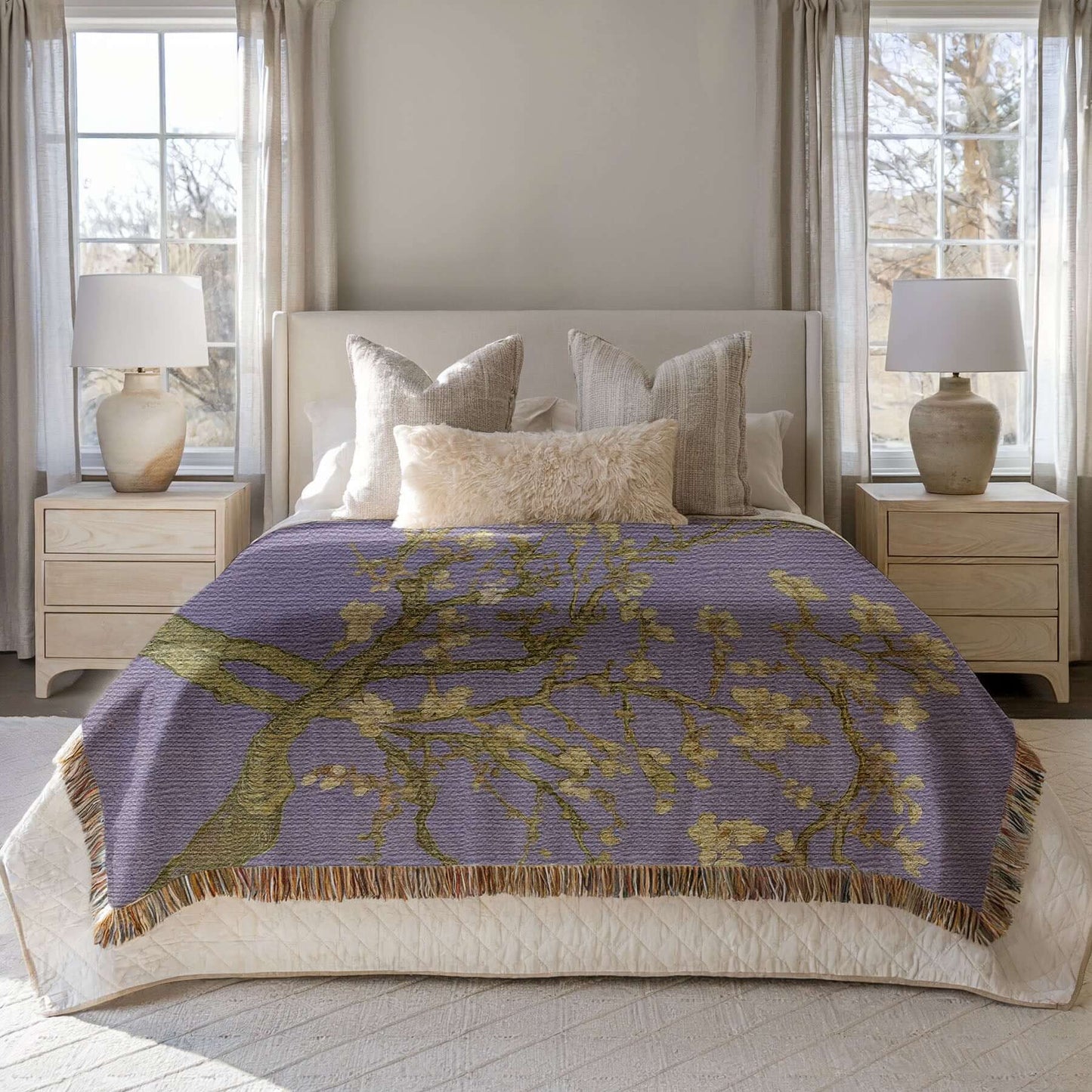 Lavender Almond Blossom Woven Blanket displayed on a bed, showcasing delicate ivory blossoms and lavender background.