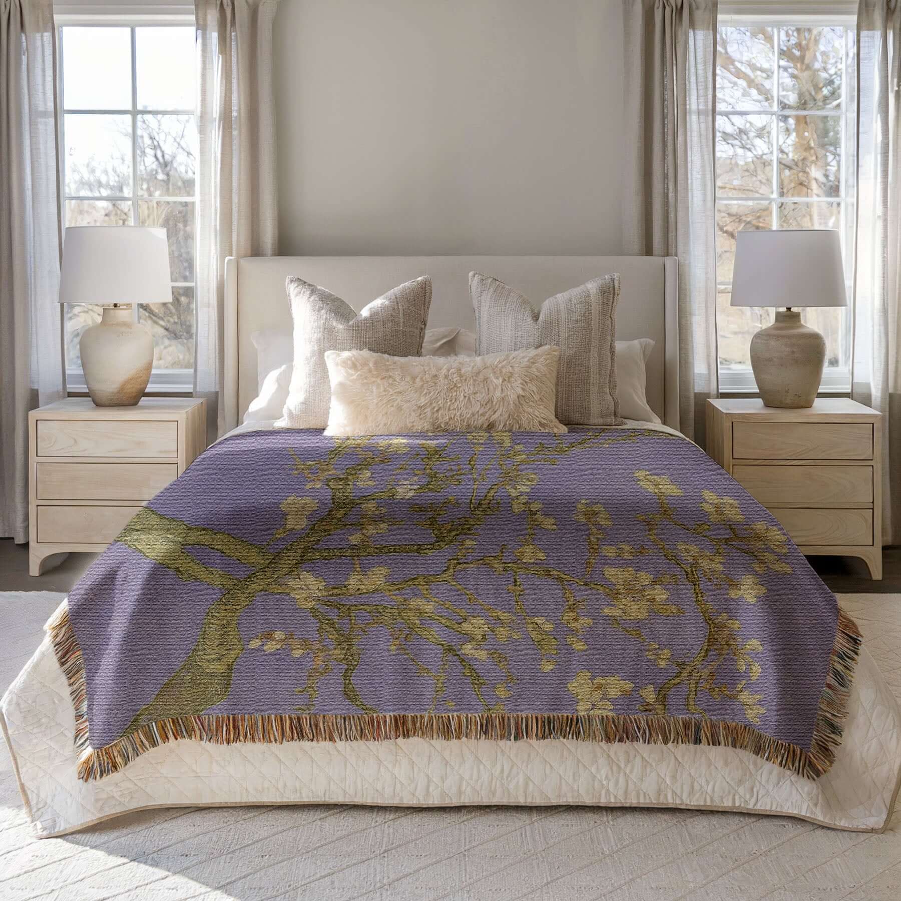 Lavender Almond Blossom Woven Blanket displayed on a bed, showcasing delicate ivory blossoms and lavender background.