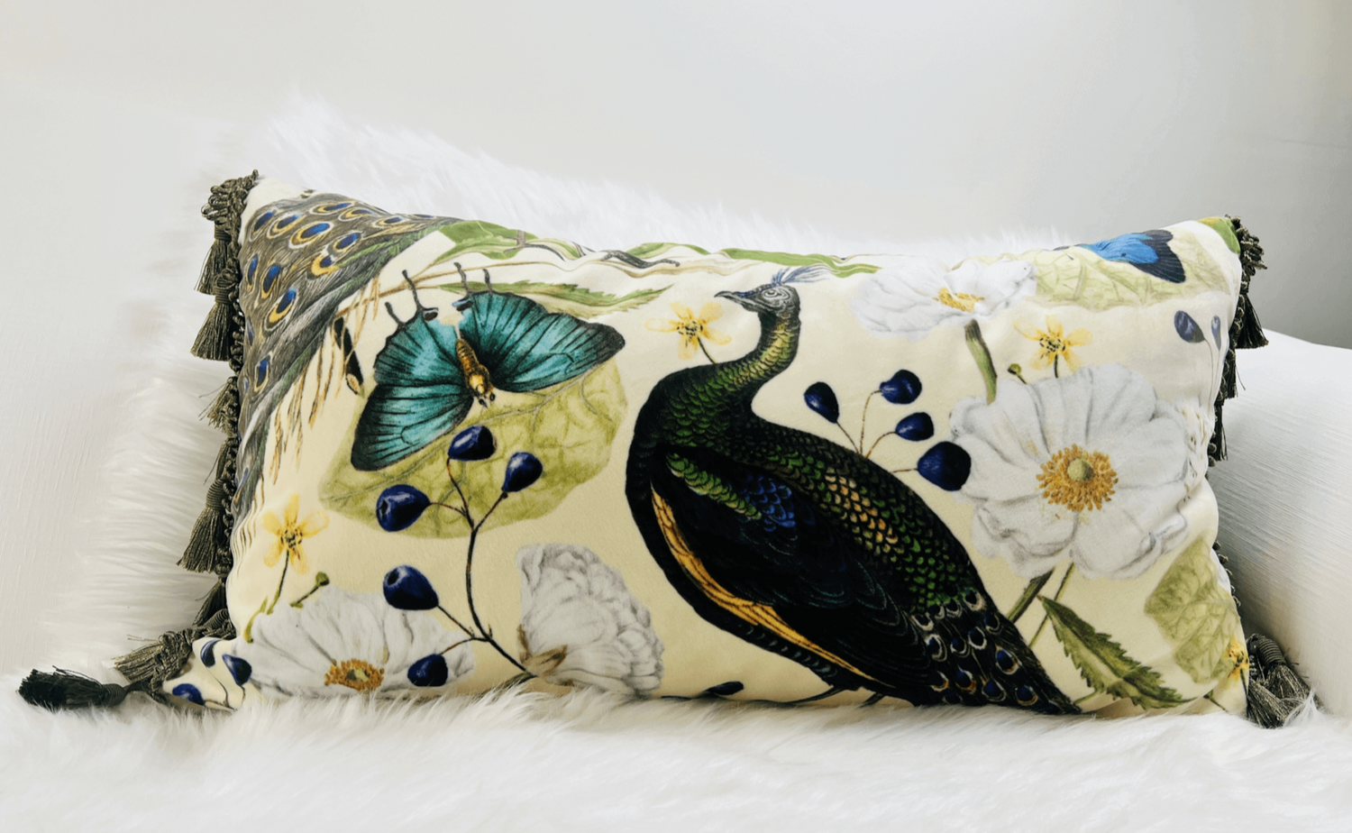 Beige Peacock Velvet Lumbar Pillow Cover with Satin Lining resting on a white sofa