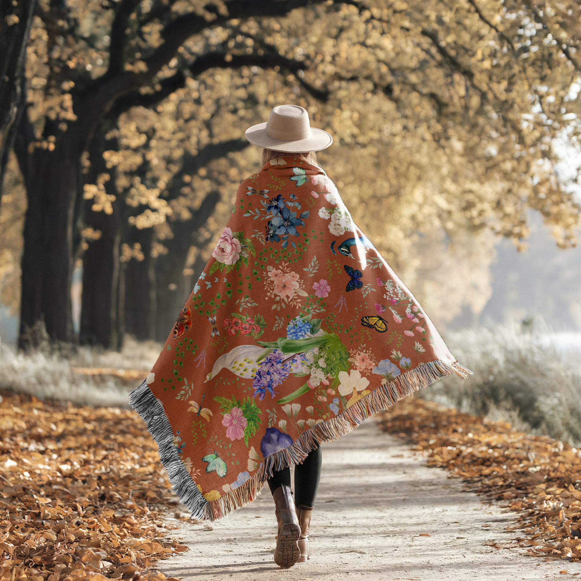 Person walking on a autumn leaf-covered sidewalk with the Cinnamon Brown Peacock Floral Woven Blanket draped over her shoulders