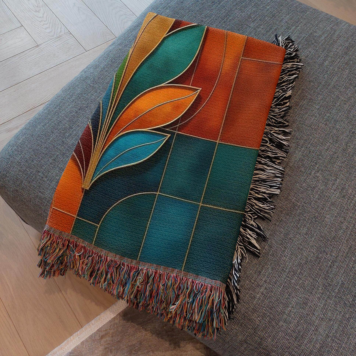 Multicolor Abstract Flower Woven Blanket Tapestry folded on an ottoman.