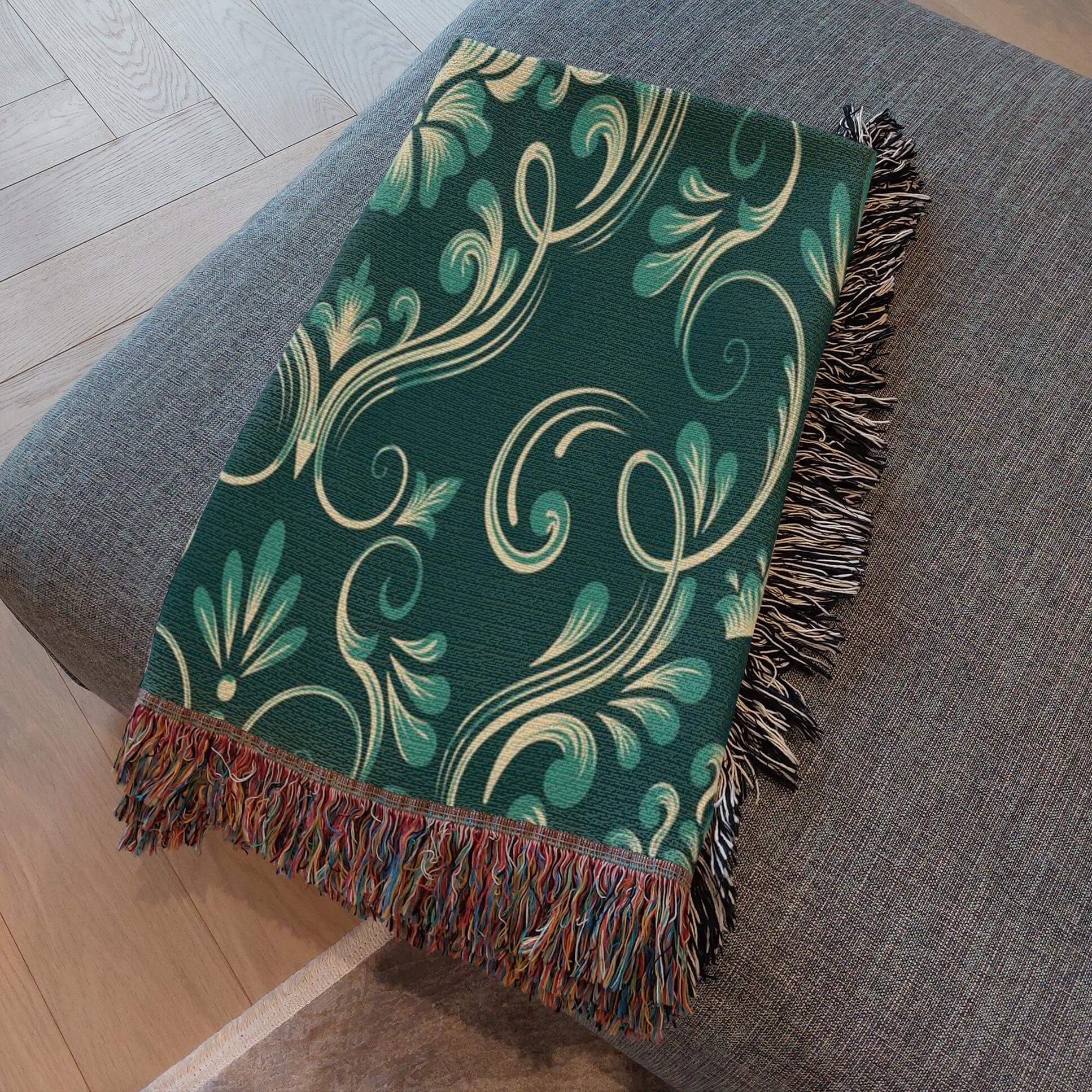  Dark Green Damask Woven Blanket  folded and resting on a gray ottoman